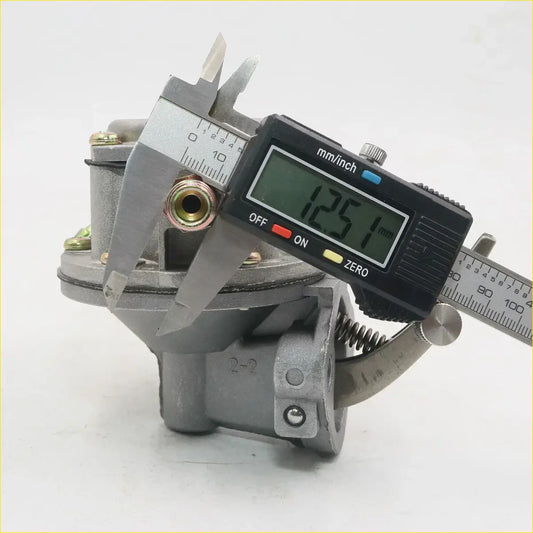 Gray metallic fuel pump carburetor for toyota hilux rn25 rn20 sr5 2-door ute being measured with digital caliper