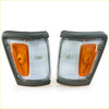 A pair of gray plastic corner indicator lights with clear and orange lenses for toyota hilux 4x4 1988-1997