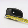 Black plastic gray lh door handle for mazda b series with smooth curved design and circular mounting hole shown from back side