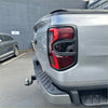 Back view of silver metallic ford ranger 2022 with black trim and red modern taillight headlight and taillight covers