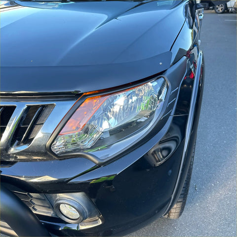Black nissan suv with sleek glossy paint and chrome grille shown with headlight and taillight covers for mitsubishi triton 2015-2018