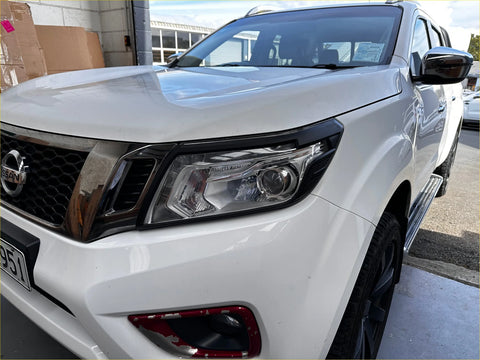 White nissan navara np300 pickup with black trim and chrome accents showing headlight and taillight covers back side