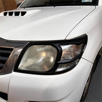 Black plastic headlight trim for white toyota hilux 2012-2015 shown from the back side for headlight covers use