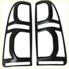 Black plastic headlight trim guards with glossy finish and angular cutouts for Toyota Hilux 2012-2015 headlights