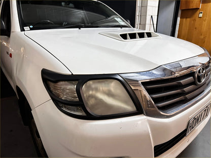White toyota hilux 2012-2015 with chrome grille and black headlight trim featuring headlight and taillight covers