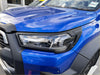Vibrant blue toyota hilux 2025 sr with matte black headlight and taillight covers featuring sleek led lights and black trim