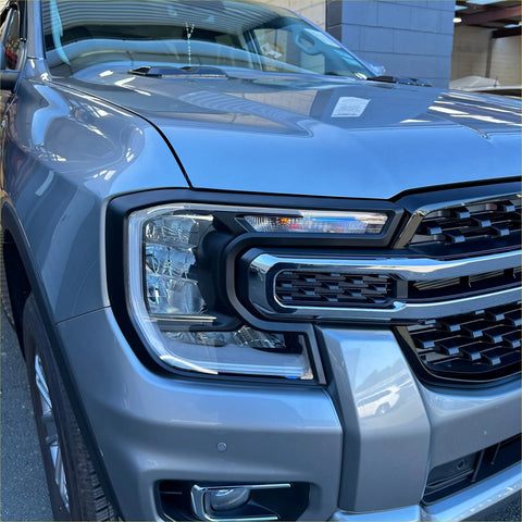 Gray metallic ford ranger with bold chrome grille and sleek led headlights featuring matte black headlight covers