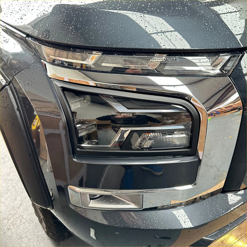 Headlight covers for mitsubishi triton 2024+ in matte black on sleek modern suv headlight with chrome accents