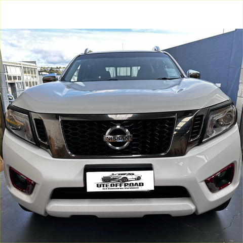 White nissan np300 pickup with black honeycomb grille and chrome accents featuring matte black headlight covers for navara 2015-2020 sl 2021+