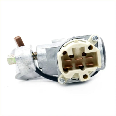 Silver metal ignition switch with beige plastic connector and copper terminals for nissan caravan urvan e25 2wd back side