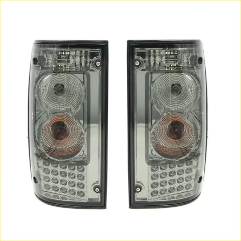 Pair of smoked led tail lights with dual circular lenses and clear led array for toyota hilux ln147 ln167 kzn165 ute