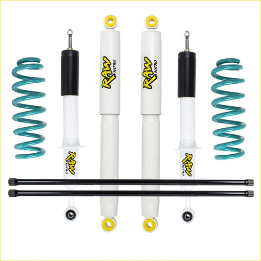 Set of four white and black raw nitro shock absorbers with yellow accents and teal coil springs for toyota hilux surf lift kit