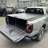 Black roll-up manual roller shutter tonneau cover on silver ford ranger 2022+ showing back side of the cover