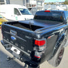 Black ford ranger xlt with sleek glossy finish and hirider badge showing manual roller shutter tonneau cover back side