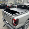 Gray metallic manual roller shutter bed cover made of metal on ford ranger sport pickup truck back side