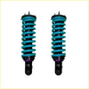 A pair of vibrant teal coil-over suspension shocks with black mounts and purple accents for mitsubishi pajero 2000 on swb