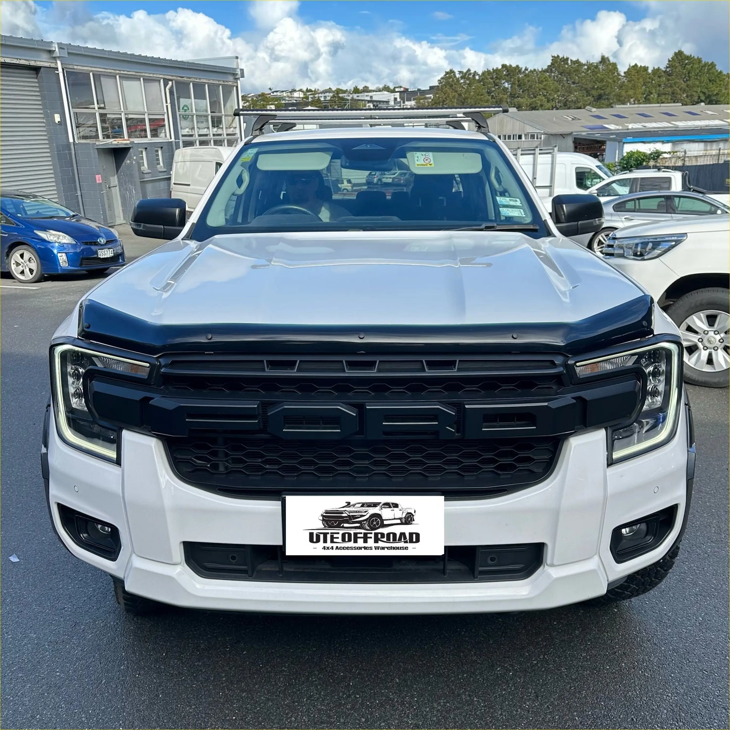 White ford ranger pickup with black front grille and roof rack featuring monsoon and bonnet guard 2022+ oem style