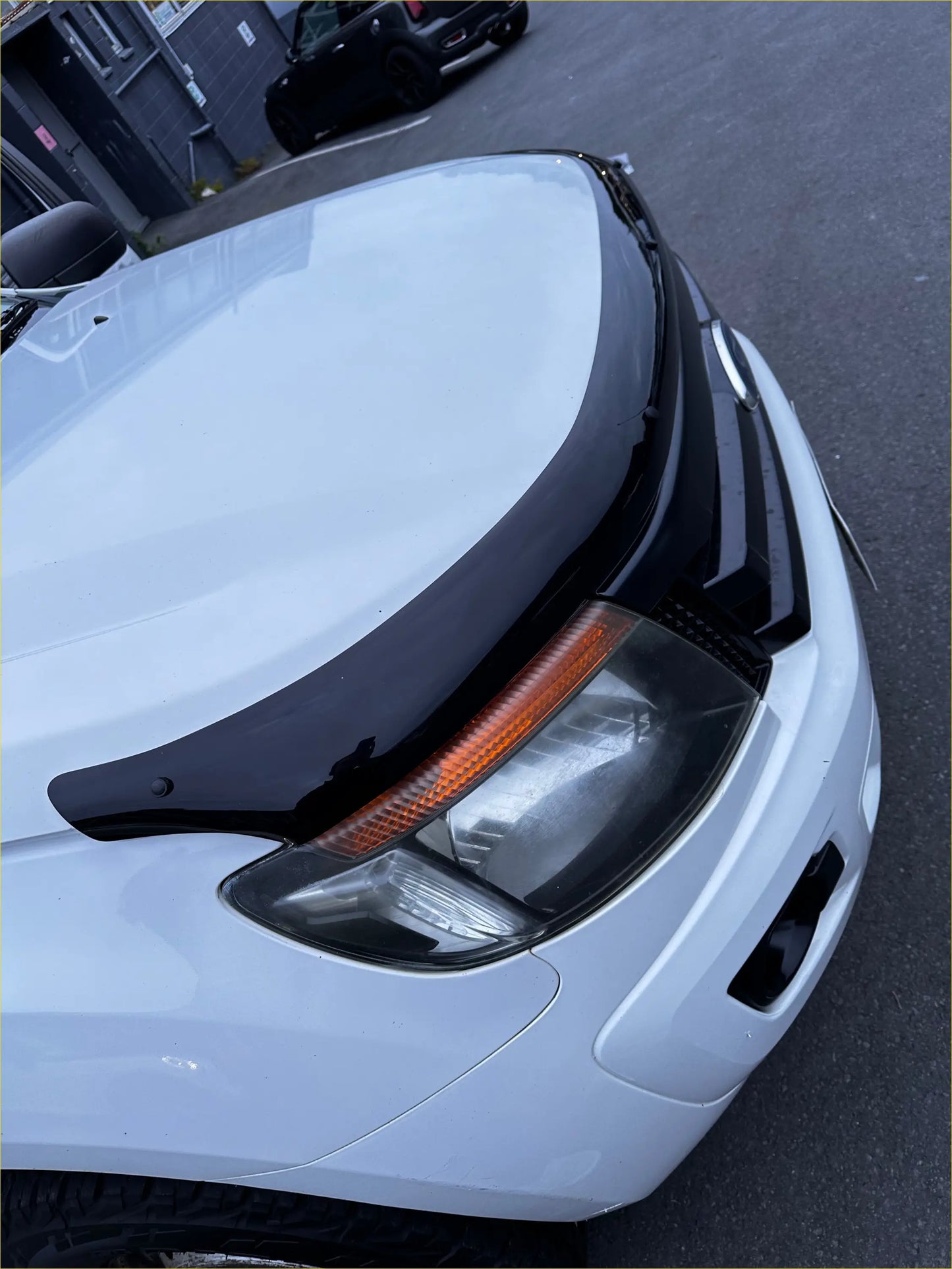 Black glossy hood ornament on white ford ranger showing monsoon and bonnet guard oem style px1 2012-2015
