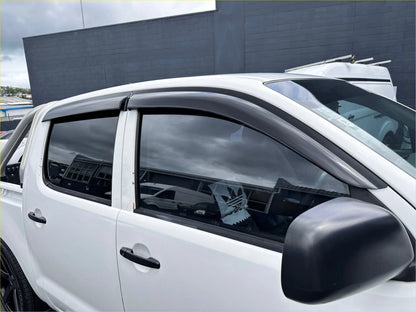 Black plastic window visors installed on a white toyota hilux 2005-2012 with monsoon and bonnet guard