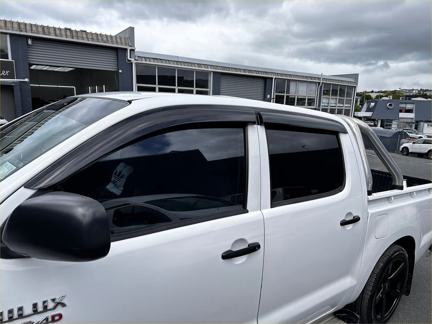 Black plastic side window visors on white toyota hilux 2005-2012 with monsoon and bonnet guard accessories