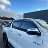 White Toyota Hilux pickup with black side mirrors and window visors featuring monsoon and bonnet guard 2021-2025