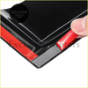 Black glossy adhesive strip with red backing being peeled off the back of monsoons window weather shield for toyota hilux