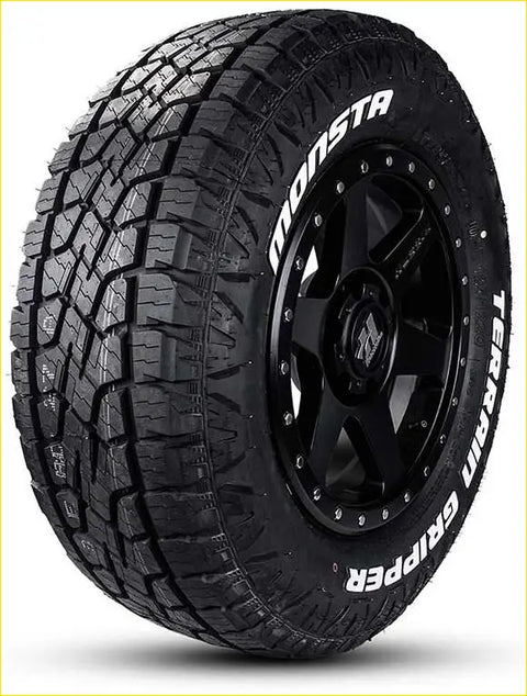 Black monsta terrain gripper at 265/50 r20 tire with deep aggressive tread on black alloy wheel