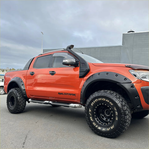 Orange ford ranger wildtrak with matte black bolt style monster flare fender flares and rugged off-road tires