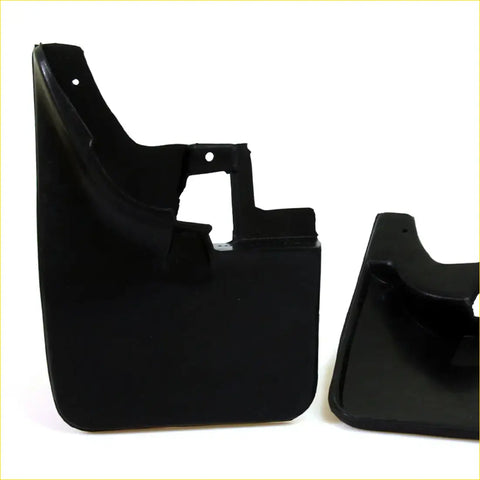 Black plastic mud flaps with molded contours and mounting holes for Nissan Navara D22 1997-2005 shown from back side