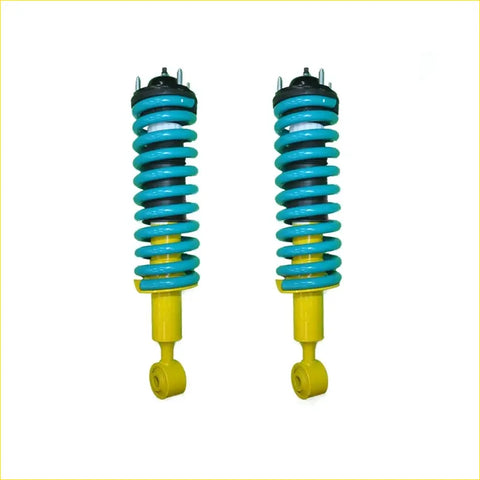 A pair of vibrant turquoise and yellow coil-over suspension shocks with black top mounts for nissan navara frontier d40 stx550