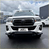 White toyota hilux pickup with black lower nudge bar compatible with front camera and sensors and roof rack