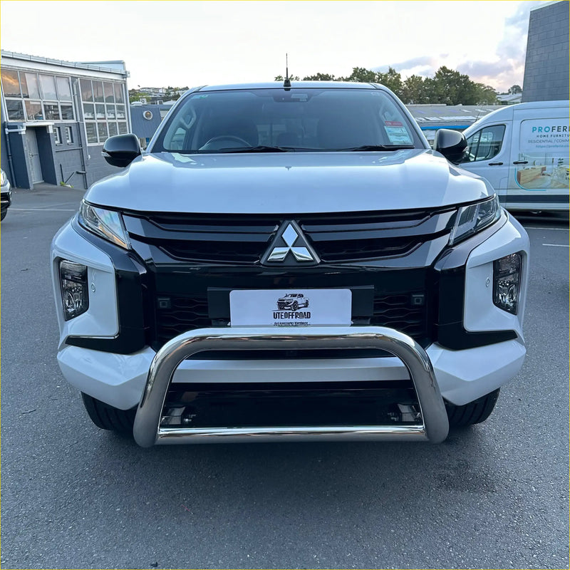 Silver chrome nudge bar with compatible front sensors mounted on the front of a white mitsubishi triton 2019-2023