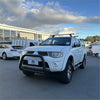 White mitsubishi triton pickup with matte black nudge bar compatible with front sensors roof rack and bumper guard