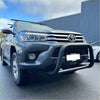 Dark gray metallic toyota hilux with matte black nudge bar compatible with front sensors roof rack and bumper guard
