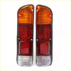 Pair of vintage-style orange and red rear combination lights with clear section in black housing for Nissan Datsun Ute 620 back side