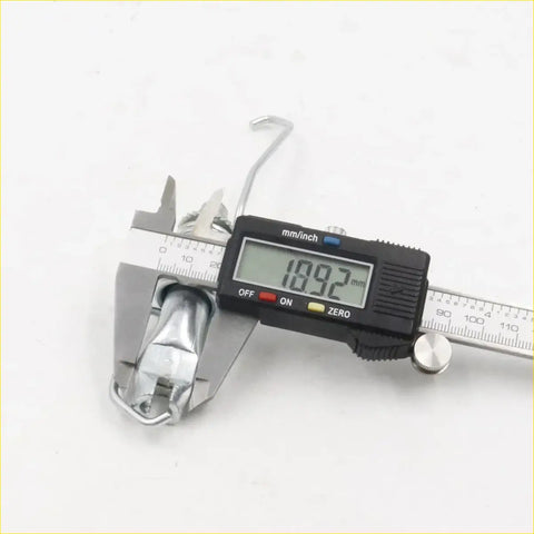 A shiny chrome metal hook of a rear drum brake shoes adjuster for toyota hilux 2wd 2005-2015 being measured
