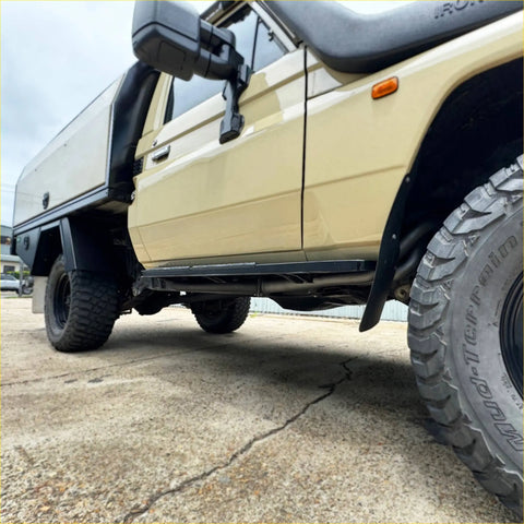 Beige toyota land cruiser 70 with black side steps and rugged tires featuring redback performance headers and exhaust