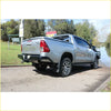 Silver toyota hilux 4wd ute with black steel rockamor elite rear step and towbar shown from the back side