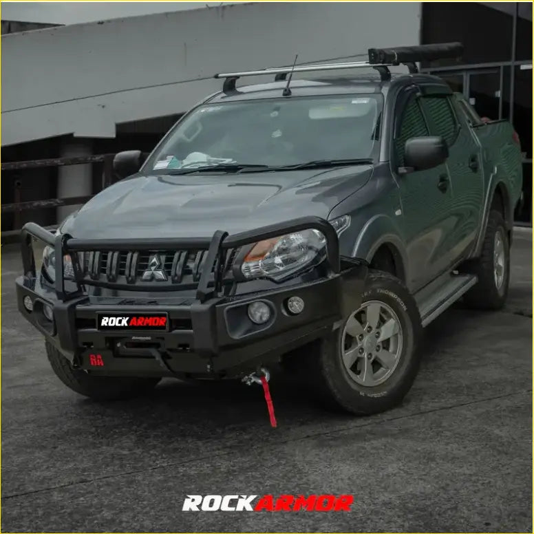 Black rockarmor elite bullbar combo pack with integrated winch and red recovery strap on dark green mitsubishi triton mq