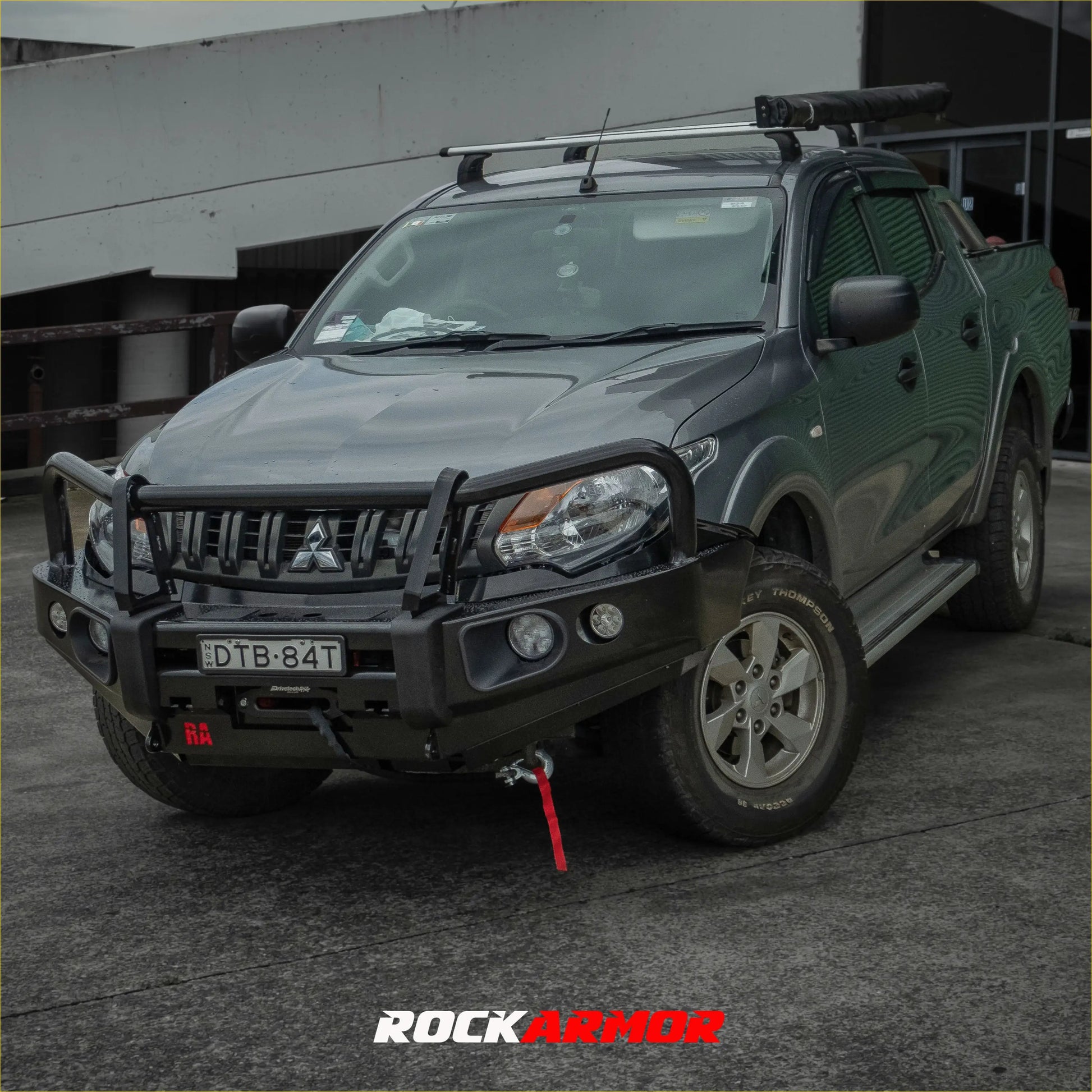 Dark gray mitsubishi triton with black rockarmor elite steel bullbar front bumper and roof rack