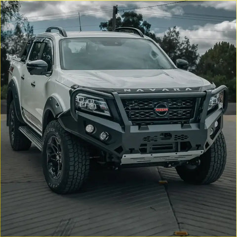 White nissan navara ute with black offroad rockarmor gt hoop bullbar combo pack and rugged 4wd tires