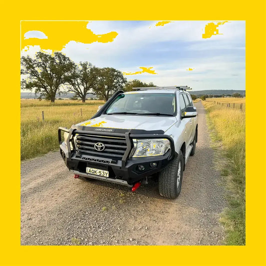 Silver toyota land cruiser with black steel rockarmor gt hoop bullbar full bar replacement and roof rack