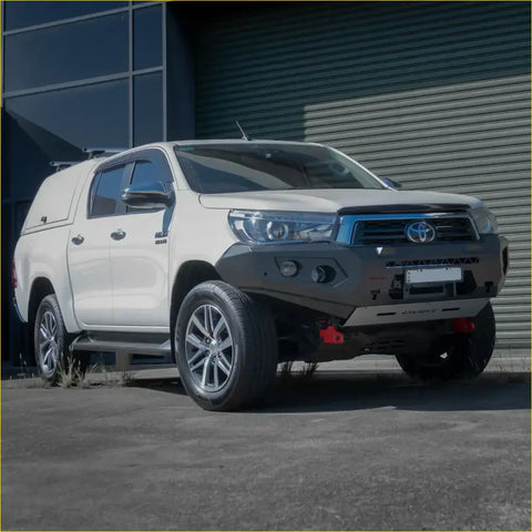 White toyota hilux 4wd ute with rockarmor gt hoopless steel bullbar and black front bumper guard for offroad use
