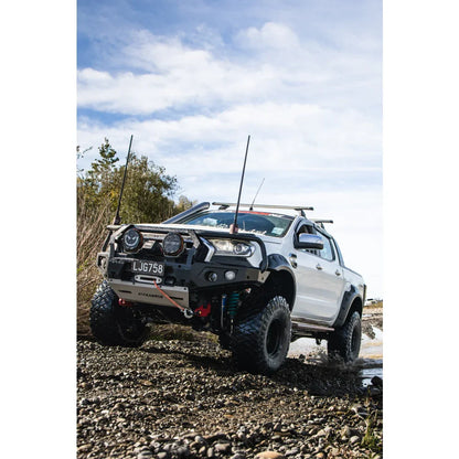 White off-road pickup truck with hoop bullbar, driving lights, and synthetic winch rope