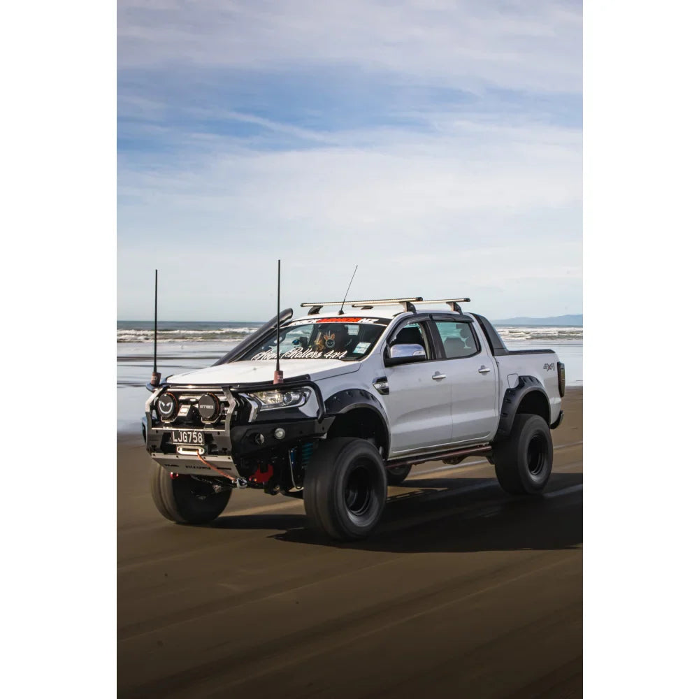 Modified white pickup truck with hoop bullbar, driving lights, and synthetic winch rope