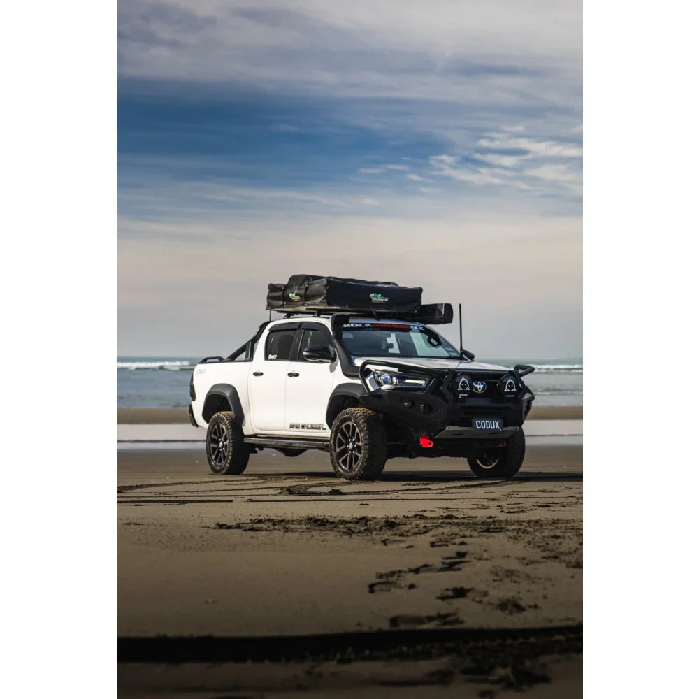 White pickup truck with roof tent showcasing Rockarmor GT Steel Hoop Bull Bar Combo Pack for Toyota Hilux 2020+