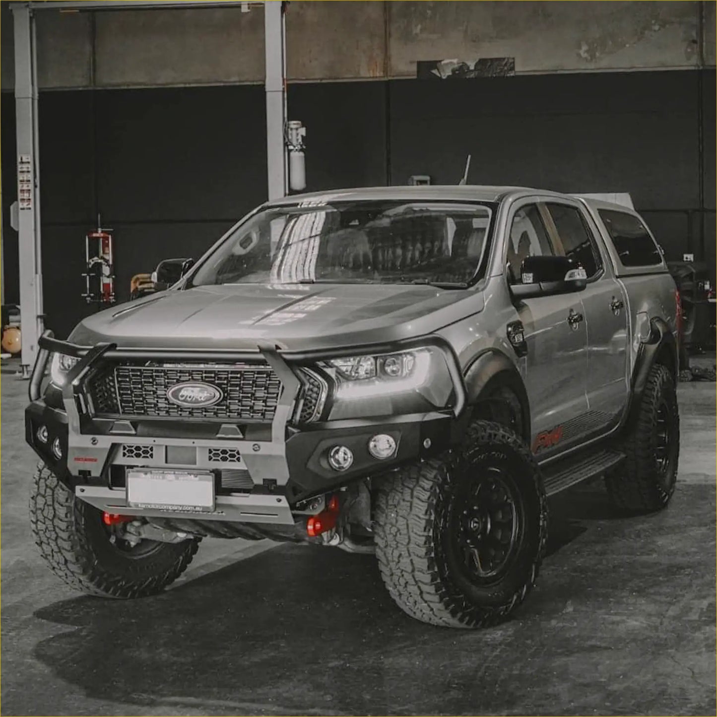 Silver ford ranger with black off-road tires featuring a rugged rockarmor gt steel hoop bullbar for px2 and 3 models