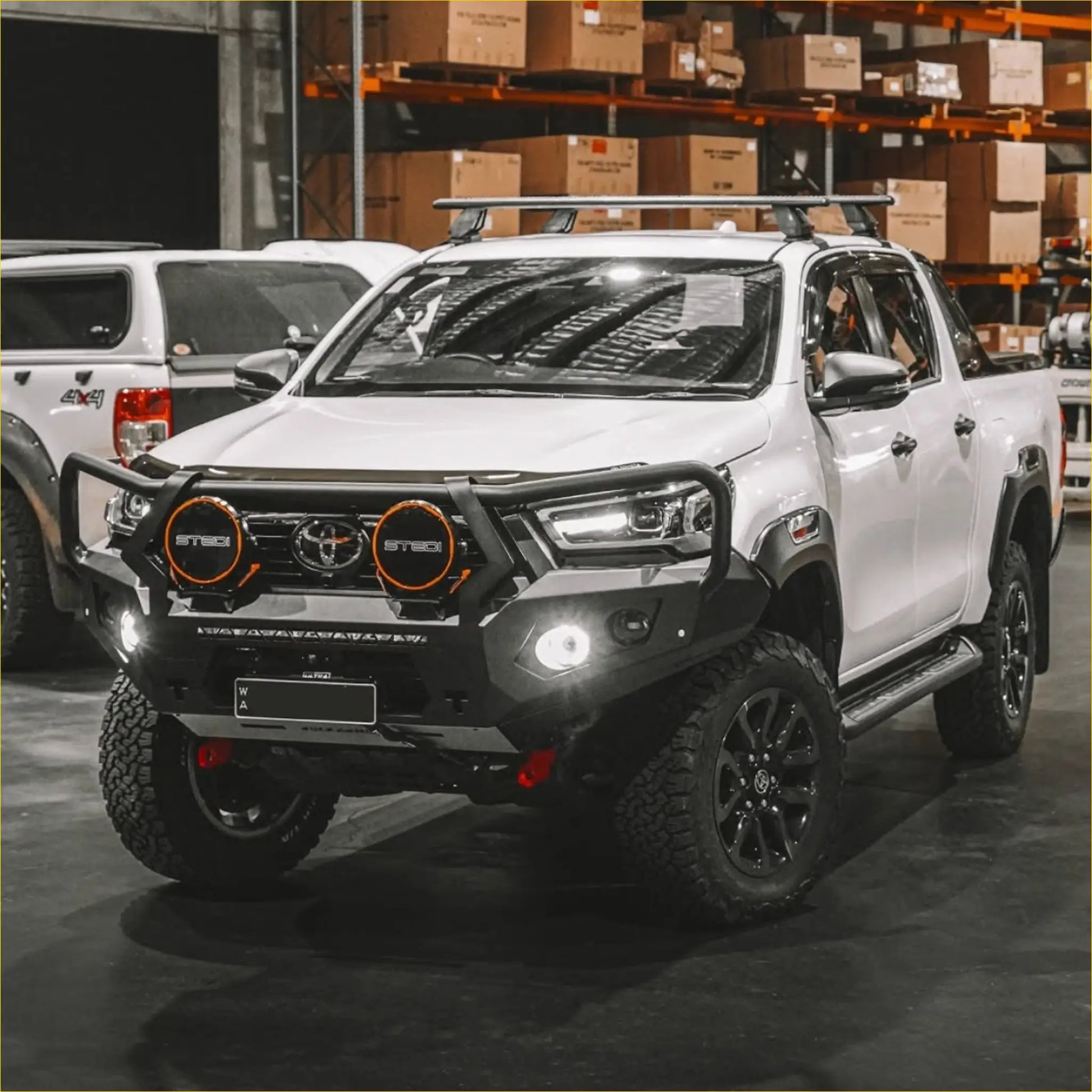 White toyota hilux 2020-2025 with black steel rockarmor gt hoop bullbar and orange-rimmed headlights off-road ready