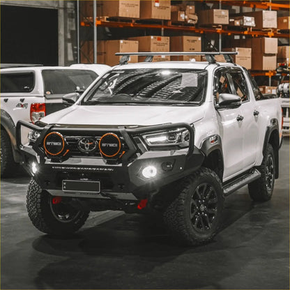 White toyota hilux 2020-2025 with black steel rockarmor gt hoop bullbar and orange-rimmed headlights off-road ready
