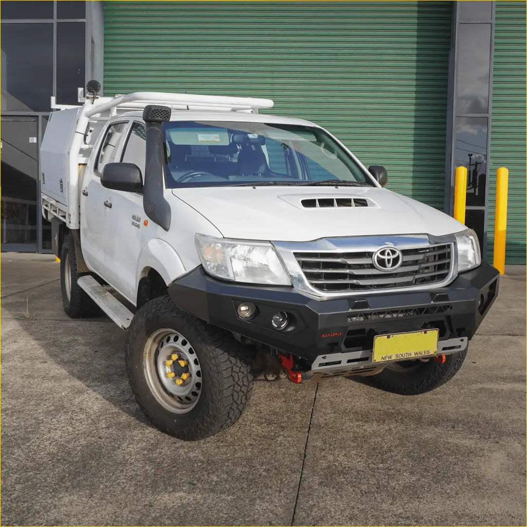 White toyota hilux with black rockarmor gt steel hoop bullbar off-road tires and roof rack for 2007-15 models